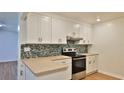 Bright kitchen with white cabinets, stainless steel range, and colorful backsplash at 1017 Chippewa Trl, Daytona Beach, FL 32117