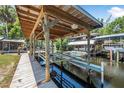 Covered boat dock on the water, featuring sturdy wooden beams, a metal roof, and lift for easy boat storage at 1085 Indigo Rd, Ormond Beach, FL 32174