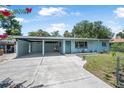 Charming single-story home with a covered patio, a well-maintained lawn, and a spacious driveway for multiple vehicles at 1085 Indigo Rd, Ormond Beach, FL 32174
