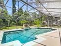 Screened-in pool area with tropical landscaping and waterfall feature for relaxing enjoyment at 1516 Arrowhead Trl, Enterprise, FL 32725