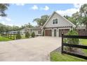 Lovely home featuring a long driveway, wooden garage doors, and mature trees at 1620 20Th St, Orange City, FL 32763