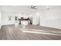 Open-concept living space with hardwood floors flowing into a modern kitchen with stainless steel appliances at 1856 9Th Ave, Deland, FL 32724
