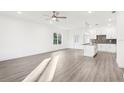 Bright and airy living room with light hardwood flooring and a view into a well-lit, modern kitchen at 1856 9Th Ave, Deland, FL 32724