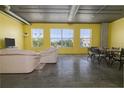 Open-concept living room with a dining area, natural light, and exposed ducts at 208 Wall St # 204, Daytona Beach, FL 32114