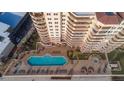 Aerial view of a condo's pool deck and lounge area, with seating, a pool, and landscaping at 2515 S Atlantic Ave # 203, Daytona Beach, FL 32118