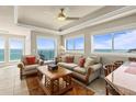 Comfortable living room featuring tile floors, tray ceiling, large windows with ocean views, and modern decor at 2801 Hill St # 801, New Smyrna Beach, FL 32169