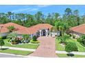 Beautiful house with mature landscaping, barrel tile roof, paver driveway, and lush landscaping at 2825 S Asciano Ct, New Smyrna Beach, FL 32168