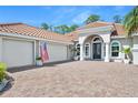 Close-up of the home's facade, including a three-car garage, grand entrance, and an American flag at 2825 S Asciano Ct, New Smyrna Beach, FL 32168