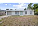 Charming single-story home with a gray garage door, white exterior, and bright blue front door at 2831 Fifer Dr, Deltona, FL 32738