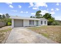 Charming single-story home with a gray garage door, white exterior, and bright blue front door at 2831 Fifer Dr, Deltona, FL 32738