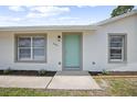 Close up on the home's front entrance featuring a bright blue door, and new landscaping at 2831 Fifer Dr, Deltona, FL 32738