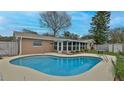 Inviting backyard featuring a private kidney-shaped swimming pool, screened in patio, and fenced perimeter at 2970 Lantern Dr, South Daytona, FL 32119