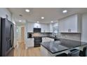 Well-lit kitchen showcasing modern white cabinetry, black appliances, and black countertops at 2970 Lantern Dr, South Daytona, FL 32119