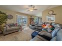 Cozy living room features tile flooring, neutral paint, and sliding door access to the backyard patio at 3013 Hunkin Cir, Deltona, FL 32738