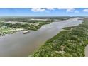 Nice aerial view of the river leading to a house with a private dock along a beautiful forested area at 317 River Front Way, Edgewater, FL 32141