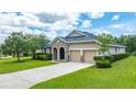 Lovely single-story home with a two-car garage, stone details, and a well maintained lawn with mature trees at 32 Abacus Ave, Ormond Beach, FL 32174