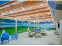 Inviting outdoor living space with an open pergola, stone patio, comfortable seating, and lush green lawn at 3324 Royal Palm Dr, Edgewater, FL 32141