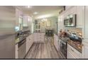 Well-appointed kitchen featuring granite countertops, stainless steel appliances, modern white cabinets and wood-look floors at 3324 Royal Palm Dr, Edgewater, FL 32141