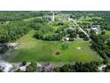 Expansive aerial view of a property featuring large fields, scattered trees, and a tranquil pond at 396 Uranus Trl, Osteen, FL 32764
