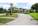 Expansive driveway leading to a well-manicured lawn and a stately home with lush greenery at 420 Greenridge Ct, Debary, FL 32713