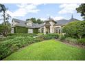 Beautiful home with a manicured lawn, lush hedges, and mature trees creating a welcoming curb appeal at 420 Greenridge Ct, Debary, FL 32713