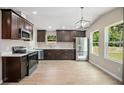 Modern kitchen features stainless steel appliances, dark wood cabinetry, and hardwood floors at 429 W Carolina Ave, Deland, FL 32720