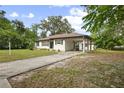 Lovely single-story home with carport surrounded by mature trees and landscaping at 431 S Stone St, Deland, FL 32720