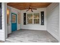 Inviting porch with stylish wood-look tile flooring, a ceiling fan, and a vibrant blue door at 431 S Stone St, Deland, FL 32720