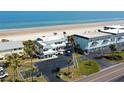 Aerial view of a beachfront property, buildings, and parking with beach access at 4786 S Atlantic Ave # 3, Ponce Inlet, FL 32127