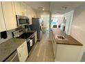Updated kitchen featuring stainless steel appliances, granite countertops, and views of the dining and living area at 4786 S Atlantic Ave # 3, Ponce Inlet, FL 32127