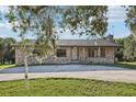 Charming stone facade home with a well-manicured lawn and mature trees creating curb appeal at 5759 Dogwood Rd, Port Orange, FL 32127