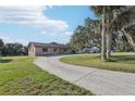 Charming stone facade home with a well-manicured lawn and mature trees creating curb appeal at 5759 Dogwood Rd, Port Orange, FL 32127