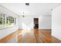Bright living room features hardwood floors, white walls, and large windows at 611 N Garfield Ave, Deland, FL 32724