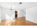 Spacious living room boasts wood floors, white walls, and an elegant chandelier at 611 N Garfield Ave, Deland, FL 32724