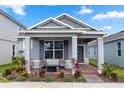 Charming single-story home with a well-manicured lawn and inviting front porch with chairs and landscaping at 614 Becklow St, Debary, FL 32713