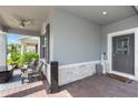 Inviting front porch with comfortable seating, brick flooring, and a ceiling fan at 614 Becklow St, Debary, FL 32713