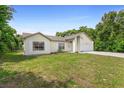Single story home with green grass, side view, and a large tree in the back at 685 N Firwood Dr, Deltona, FL 32725
