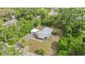 An aerial view of a well-maintained single-story home with a detached garage, and lush greenery at 710 W May St, Deland, FL 32720