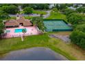 Aerial view showcasing community pool, tennis courts, clubhouse, and lush greenery at 955 Grayling Ct # B, Port Orange, FL 32127