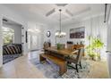 Bright dining room with a rustic wooden table, stylish chandelier, and coffered ceilings at 101 Briargate Look, Ormond Beach, FL 32174