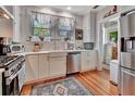 Well-lit kitchen featuring stainless steel appliances, white cabinetry, and a farmhouse sink, blending modern amenities with classic charm at 1056 Stevens St, Lake Helen, FL 32744