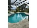 Screened-in pool with spa and lakeside view, perfect for relaxation and enjoying the outdoors at 1118 Prescott Blvd, Deltona, FL 32738