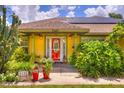 Inviting front entrance with a red door, potted plants, and manicured shrubs at 1131 Lemonwood Ave, Deland, FL 32724