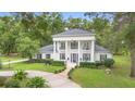 Elegant two-story home boasting grand columns, dark shutters, and meticulously manicured landscaping at 1155 Taylor E Rd, Deland, FL 32724