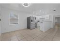 Modern kitchen with stainless steel appliances, white cabinetry, and tiled floor, perfect for culinary enthusiasts at 1214 Flomich St, Daytona Beach, FL 32117