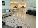 Open-concept living room with ceramic tile flooring and views into the dining and kitchen areas, great for entertaining at 1216 August Sky Dr, Deltona, FL 32738