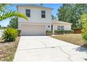 Bright two-story home with a manicured lawn, a two-car garage, and tidy landscaping at 1561 Randolph St, Deltona, FL 32725
