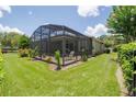 Backyard boasts a screened patio, lush lawn, complemented by vibrant flowers and greenery at 1653 Victoria Gardens Dr, Deland, FL 32724