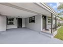 Spacious covered porch area featuring neutral paint, lighting, and access to the front door and side entrance at 173 Cedar Ave, Orange City, FL 32763