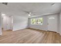 Bright living room showcasing modern flooring, a ceiling fan, and a new front door and large window at 173 Cedar Ave, Orange City, FL 32763